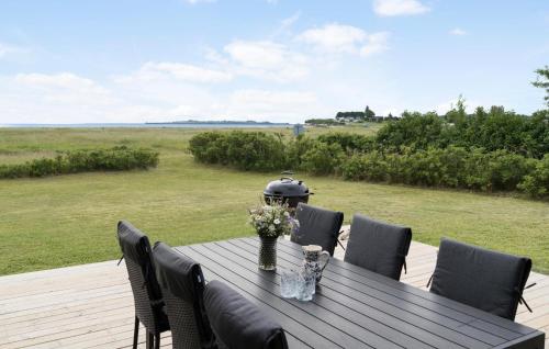 a wooden table with chairs and flowers on a deck at Awesome Home In Haderslev With Wifi in Haderslev