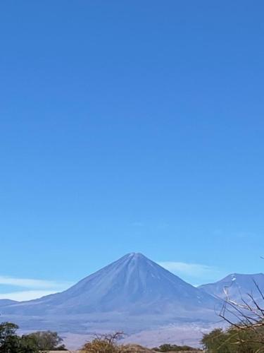 a mountain in the distance with a blue sky at Dunas de tulor in San Pedro de Atacama