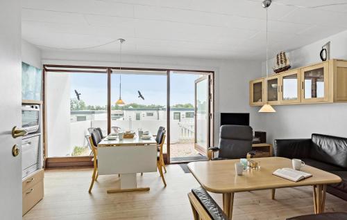a living room with a dining room table and a kitchen at Terrassehus in Fæbæk