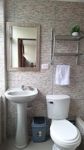 bagno con lavandino, servizi igienici e specchio di Hotel Cajamarquez a Cajamarca