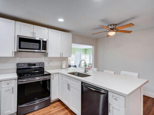 a kitchen with white cabinets and a ceiling fan at Luxury Miami Casa Bonita with Tropical Pool Oasis in Miami