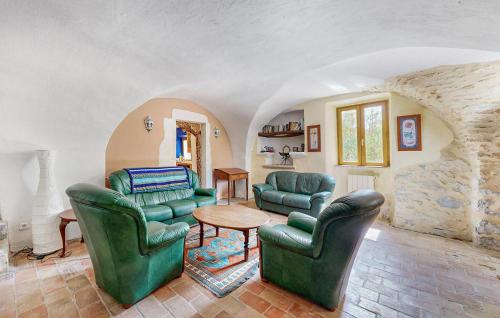 - un salon avec deux chaises vertes et une table dans l'établissement Le Mas Veissiere, à Lussan