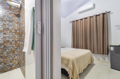 a bedroom with a bed and a brick wall at Pousada Por do Sol in Pirenópolis