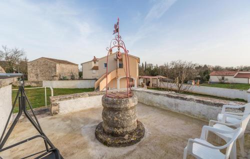 a statue on top of a building with two white chairs at Awesome Home In Segotici in Šegotići