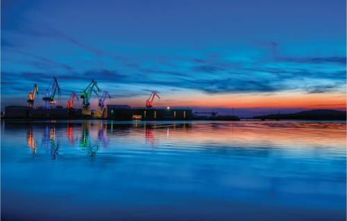 a sunset over a body of water with cranes at Awesome Home In Segotici in Šegotići