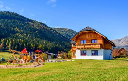 a wooden house with a playground in a field at Ferienwohnung In Weißpriach in Weisspriach