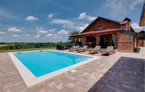 a swimming pool with chairs and a house at Nice Home In Gornje Plavnice With Wifi in Gornje Plavnice