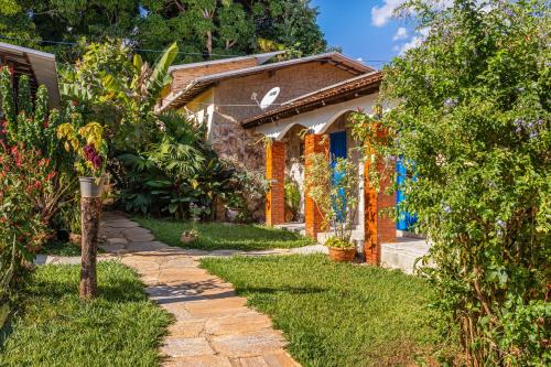 a house with a garden and a pathway at Pousada Por do Sol in Pirenópolis