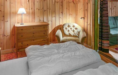 a bedroom with a bed and a chair and a dresser at 4 Bedroom Amazing Home In Sysslebäck in Sysslebäck