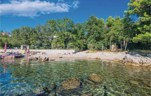 a group of people in the water at a beach at Beautiful Apartment In Omisalj in Omišalj