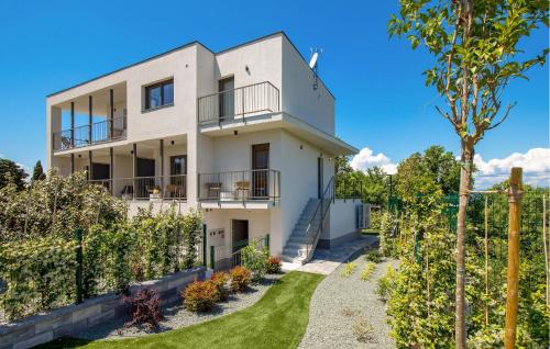 an exterior view of a white house with a yard at Amazing Apartment In Omisalj in Omišalj