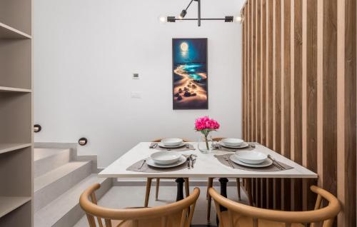 a dining room with a white table and chairs at Amazing Apartment In Omisalj in Omišalj
