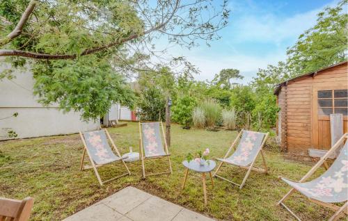 three chairs and a table in a yard at Gorgeous Home In Saint-Georges-De-Didon in Saint-Georges-de-Didonne