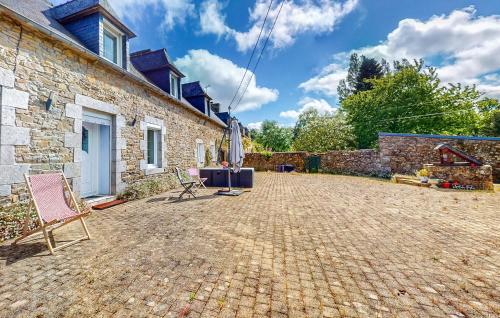 a patio of a house with a chair and an umbrella at Nice Home In Plouagat With Wifi in Plouagat