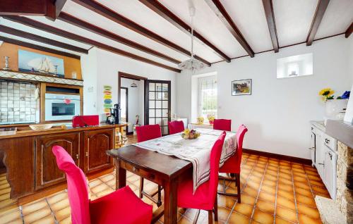 a kitchen and dining room with a table and red chairs at Nice Home In Plouagat With Wifi in Plouagat