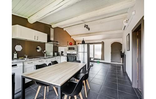 une cuisine avec une table et des chaises en bois dans l'établissement Nice Home In St-Génies-De-Comolas, à Saint-Geniès-de-Comolas