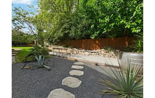 un jardin avec des rochers et un mur en pierre dans l'établissement Nice Home In St-Génies-De-Comolas, à Saint-Geniès-de-Comolas