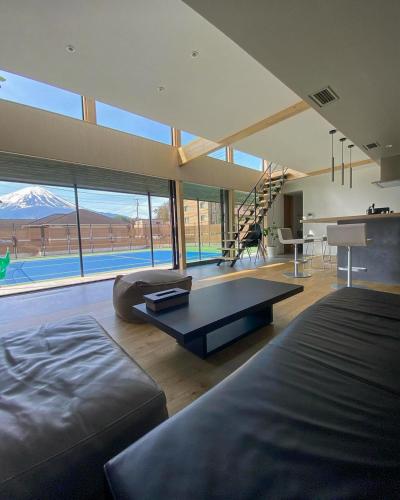 a large living room with a couch and a table at Mount Fuji view プライベートテニスコート付き高級リゾートヴィラ MAAA in Fujikawaguchiko