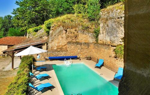une vue aérienne d'une piscine avec des chaises et un parasol dans l'établissement Le Treil, à Beynac-et-Cazenac