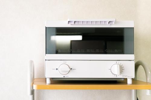 a microwave oven sitting on top of a wooden shelf at 44, Sumiyoshi 2, Entire house for rent, 住吉2 in Tokyo