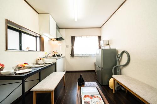 a kitchen with a refrigerator and a table and chairs at 44, Sumiyoshi 2, Entire house for rent, 住吉2 in Tokyo