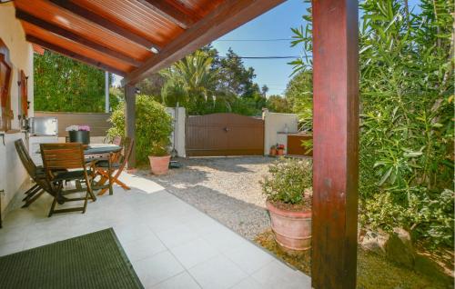 a patio with a table and chairs and a fence at 2 Bedroom Awesome Home In Albitreccia in Albitreccia
