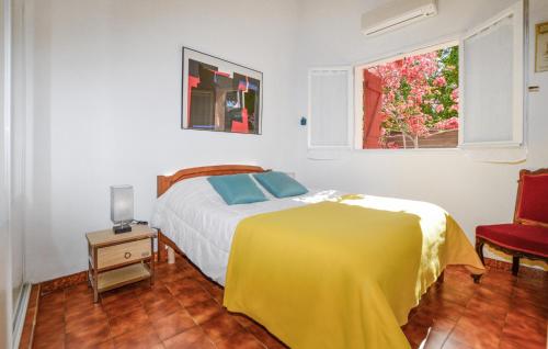 - une chambre avec un lit doté d'une couverture jaune et d'une fenêtre dans l'établissement 2 Bedroom Awesome Home In Albitreccia, à Albitreccia