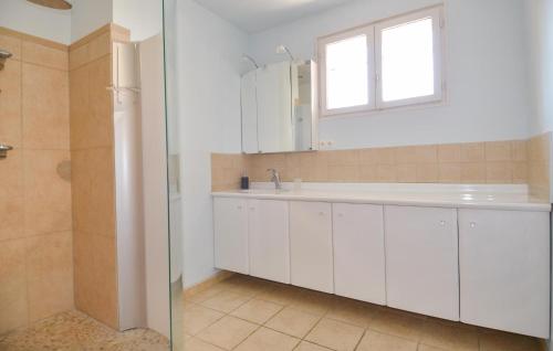 a white bathroom with a sink and a window at Awesome Home In Saint-Siffret With Wifi in Saint-Siffret