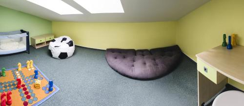 Habitación infantil con sofá y pelota de fútbol en Hotel Purkmistr, en Plzeň