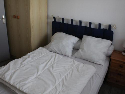 d'un lit non aménagé avec des draps et des oreillers blancs. dans l'établissement Appartement T2 près de la plage, animaux admis - FR-1-482-145, à Fort-Mahon-Plage