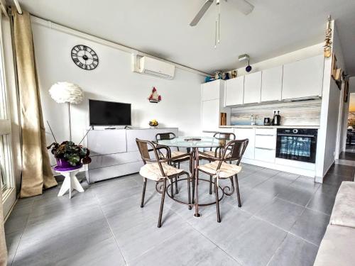 une cuisine et une salle à manger avec une table et des chaises dans l'établissement Appartement T2 à Saint-Cyprien - Terrasse, Clim et Parking - Proche Plage et Commerces - FR-1-309-470, à Saint-Cyprien