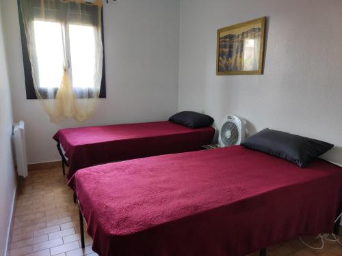 Cette chambre comprend deux lits et un ventilateur. dans l'établissement Appartement Familial 6 Pers, Piscine, Tennis, Parking Privé, à 500m des Plages d’Argelès. - FR-1-776-99, à Argelès-sur-Mer