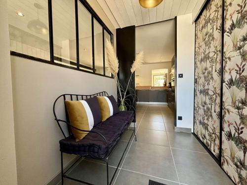 un couloir avec une chaise avec des coussins jaunes dessus dans l'établissement Maison rénovée St-Pierre d'Oléron, 4 pers, proche centre, extérieurs agréables, parking, vélos inclus - FR-1-246A-317, à Saint-Pierre-dʼOléron