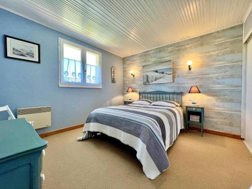 ein Schlafzimmer mit einem Bett und einer Holzwand in der Unterkunft Maison familiale à La Brée-les-Bains - 3 chambres, terrasse, près de la plage - FR-1-246A-318 in La Brée-les-Bains