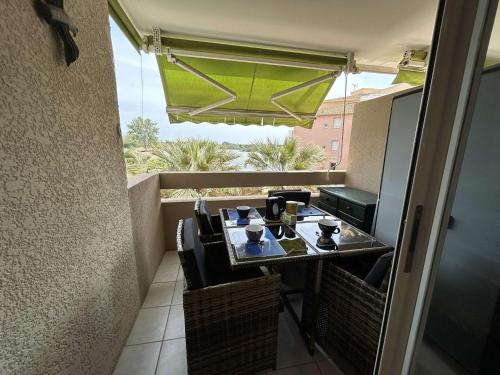 une table et des chaises sur un balcon avec vue dans l'établissement Appt 2P 6 pers avec piscine et parking à Port Camargue - FR-1-250-288, au Grau-du-Roi