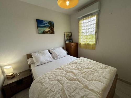 une chambre avec un lit blanc et une fenêtre dans l'établissement Appt 2P 6 pers avec piscine et parking à Port Camargue - FR-1-250-288, au Grau-du-Roi