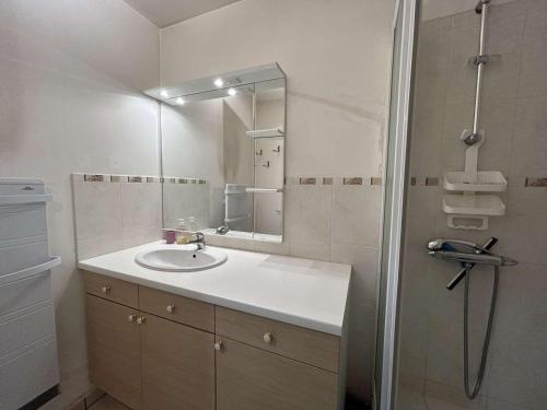 une salle de bain avec un lavabo et un miroir dans l'établissement Appartement 2 pièces avec loggia, à 100m de la plage - 4 couchages, TV, lave-linge, proche commerces - FR-1-224C-311, à Saint-Hilaire-de-Riez