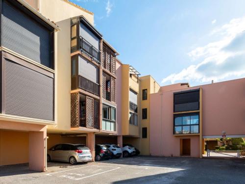 Une rangée de bâtiments avec des voitures garées dans un parking dans l'établissement Appartement familial 2 pièces cabine, à 60m de la plage, avec box et Wi-Fi - Saint Pierre la Mer - FR-1-229D-140, à Fleury