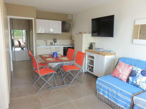 un salon avec une table et des chaises et une cuisine dans l'établissement Studio refait avec piscine et clim, proche plage et commerces - FR-1-731-81, au Grau-du-Roi