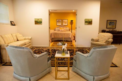 a living room with two chairs and a bed at Beautiful Parkside Suite in Saint James