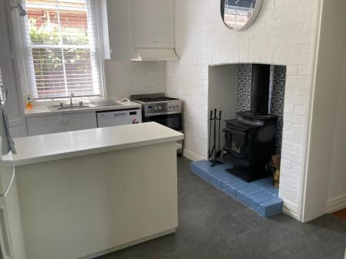 a kitchen with a stove and a fireplace at Kilparney House in Benalla