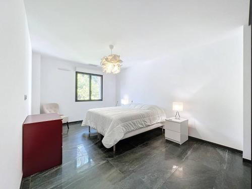 - une chambre blanche avec un lit et un lustre dans l'établissement Appartement de standing 100m de la plage - 2 chambres, climatisation, parking, WiFi - FR-1-770-36, à Saint-Cyr-sur-Mer