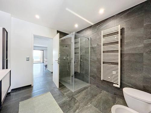 une salle de bain avec une douche en verre et des toilettes dans l'établissement Appartement de standing 100m de la plage - 2 chambres, climatisation, parking, WiFi - FR-1-770-36, à Saint-Cyr-sur-Mer