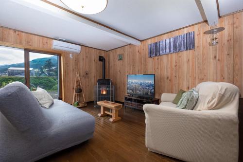a living room with two chairs and a television at Togari Cottage 2LDK Vacation Home - Pets OK in Iiyama