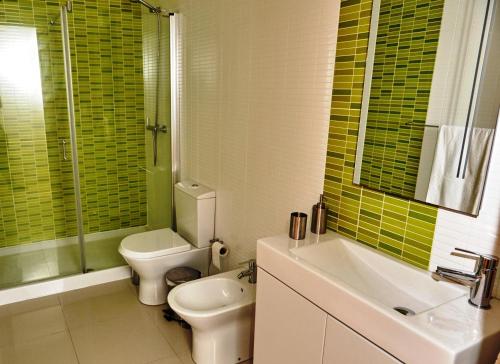 a bathroom with a toilet and a sink and a shower at Casas da Bica - Homes with Soul in Mira Olhos