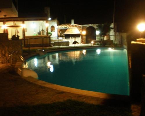 a swimming pool in a yard at night at Petrochori ApartHotel in Petrochori