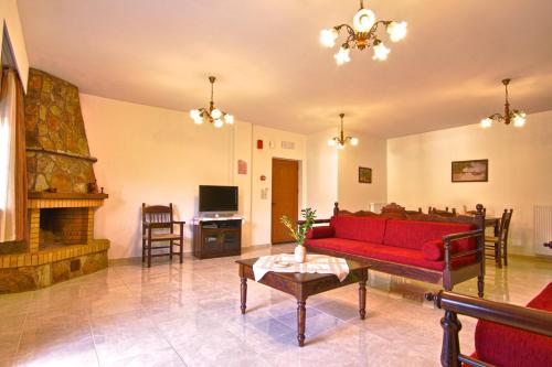 a living room with a red couch and a fireplace at Petrochori ApartHotel in Petrochori