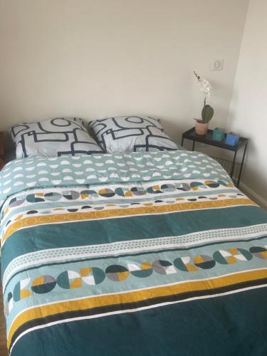 - un lit avec une couette bleue dans l'établissement Apparemment front de mer, à Ouistreham