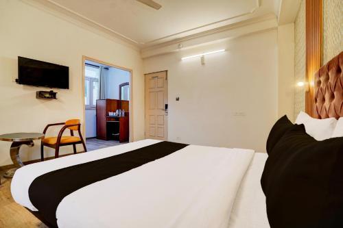 a bedroom with a large white bed and a table at Super Hotel JP Palace in New Delhi