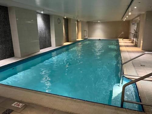 a large indoor swimming pool with blue water at Central CBD 3BR Apt - 150m to Darling Harbour & ICC in Sydney